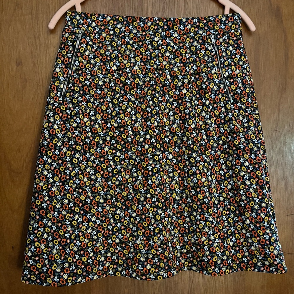 Skater style skirt with multicolor flower print on a black background